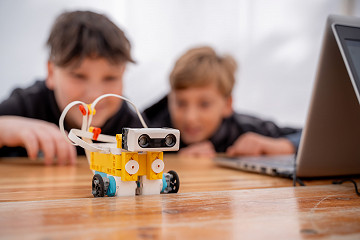 Kinder programmieren einen LEGO-Roboter.